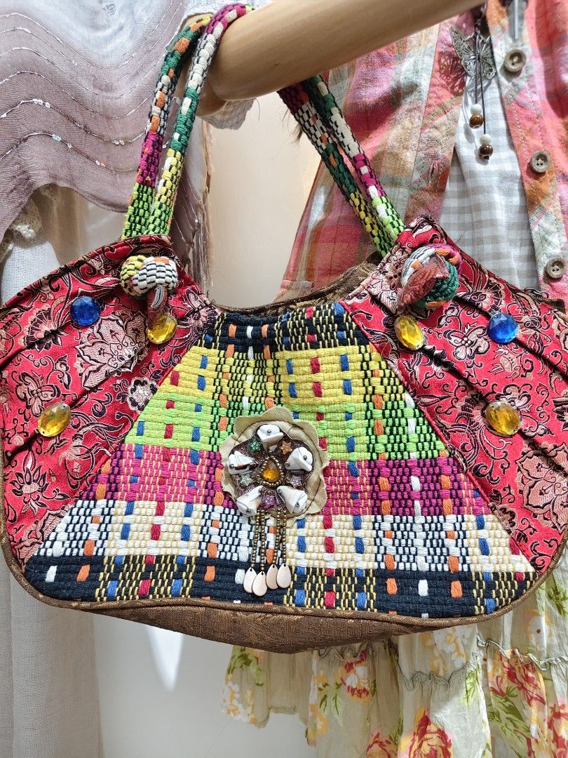 CD:B02 Fairy Boho shoulder bag (Category: Shoulder Bags) located in Manila. Submitted by chynii_28 (Listing ID 1468132089, Image 3). Description: - Style: Fairy boho shoulder bag with colorful woven and patterned fabric - Accents: Embellished with colorful gems, beads, and a central shell - Straps: Twin shoulder straps in green and patterned fabric (17" strap length) - Dimensions: 10" length/height x 17.5" width - Condition: Clean interior and ex