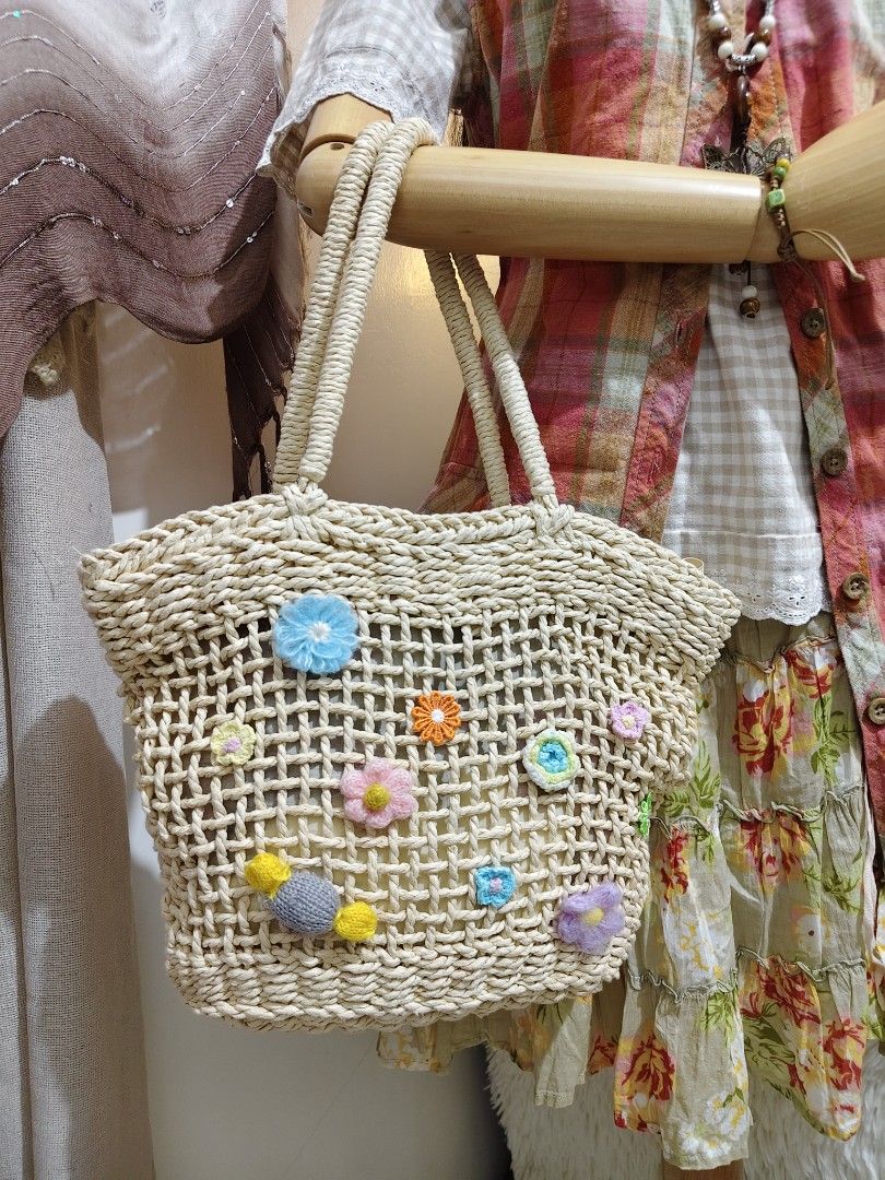 CD:B03 Cottage core rattan shoulder bag (Category: Shoulder Bags) located in Manila. Submitted by chynii_28 (Listing ID 1468136094, Image 2). Description: - Style: Cottagecore rattan shoulder bag (CD:B03) - Design: Cream-colored woven rattan with colorful crochet flowers and a front candy accent - Dimensions: 10" Length x 10" Height x 15" Width - Strap: 17" shoulder strap drop - Closure: Secure zip closure - Condition: Stains present on the inner