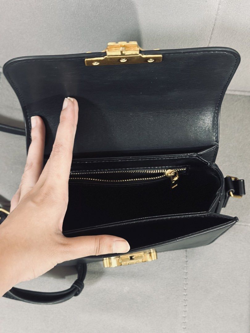 Celine Black Leather Triomphe Shoulder Bag (Category: Luxury Bags & Wallets) located in Tarlac. Submitted by via_banana (Listing ID 1468096279, Image 3). Description: - Brand: Celine - Material: Black leather - Hardware: Gold-tone Triomphe closure - Strap: Adjustable shoulder strap - Interior: Clean lining with multiple compartments and a zipped back pocket - Condition: Minor signs of handling on the exterior, great for everyday wear.