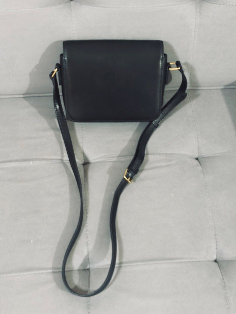 Celine Black Leather Triomphe Shoulder Bag (Category: Luxury Bags & Wallets) located in Tarlac. Submitted by via_banana (Listing ID 1468096279, Image 2). Description: - Brand: Celine - Material: Black leather - Hardware: Gold-tone Triomphe closure - Strap: Adjustable shoulder strap - Interior: Clean lining with multiple compartments and a zipped back pocket - Condition: Minor signs of handling on the exterior, great for everyday wear.