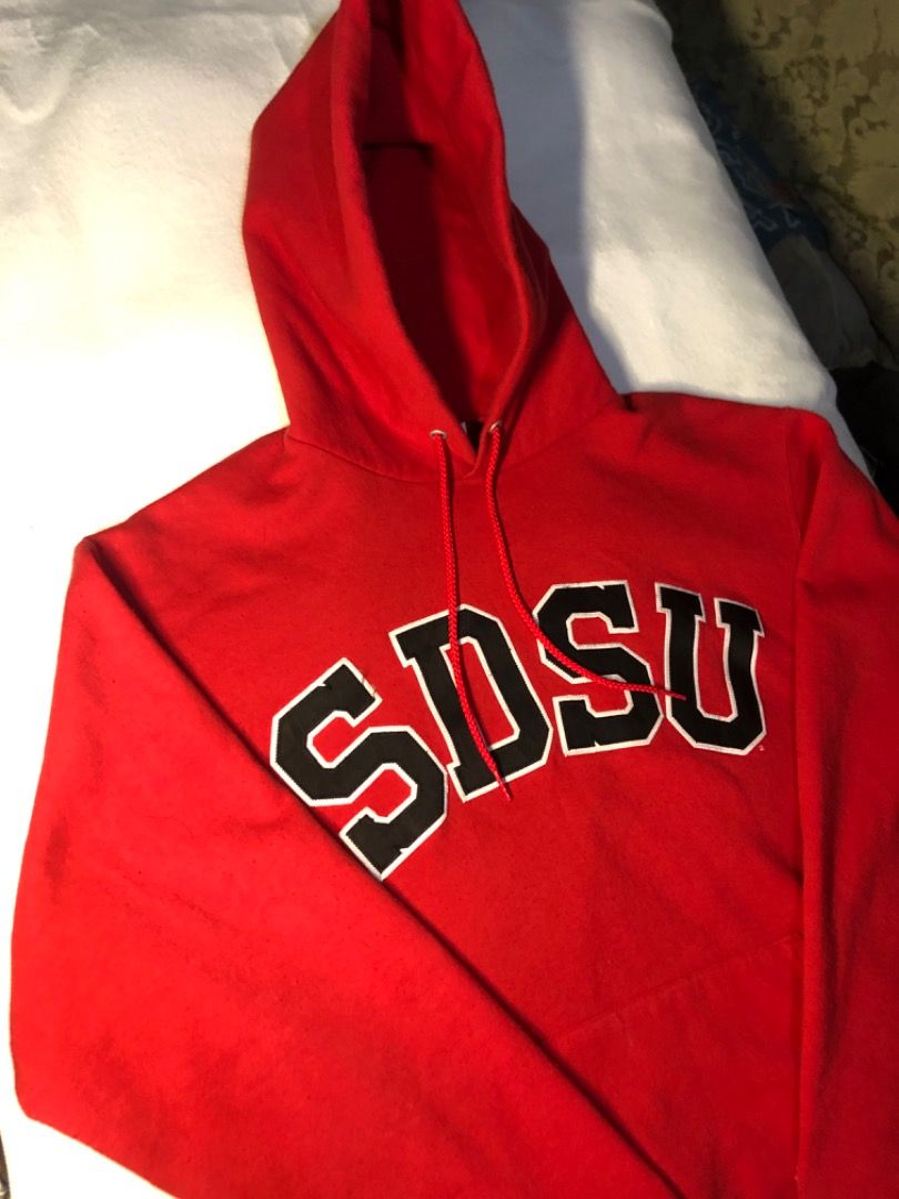 Champion SDSU Red Collegiate Hoodie (Category: Hoodies) located in Cavite. Submitted by puredolphin.2b4cb1 (Listing ID 1468143537, Image 1). Description: - Brand: Champion - Style: Hoodie with front pouch pocket and drawstring hood - Design: SDSU collegiate lettering across the chest - Color: Red - Size: Medium (M) - Material: 50% cotton, 50% polyester blend - Origin: Made in El Salvador.