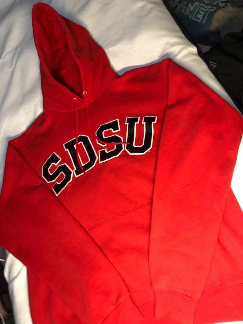 Champion SDSU Red Collegiate Hoodie (Category: Hoodies) located in Cavite. Submitted by puredolphin.2b4cb1 (Listing ID 1468143537, Image 3). Description: - Brand: Champion - Style: Hoodie with front pouch pocket and drawstring hood - Design: SDSU collegiate lettering across the chest - Color: Red - Size: Medium (M) - Material: 50% cotton, 50% polyester blend - Origin: Made in El Salvador.