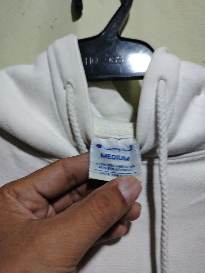 Champion White Hoodie Sweatshirt Medium (Category: Hoodies) located in Caloocan City. Submitted by vincefresn21903 (Listing ID 1468281752, Image 2). Description: - Brand: Champion - Style: Pullover hoodie with standard fit - Color: Classic White - Size: Medium - Design: Large script logo across the chest - Features: Kangaroo front pocket, drawstring hood, ribbed cuffs and hem - Detail: Small embroidered 'C' patch on the left wrist - Material: Com