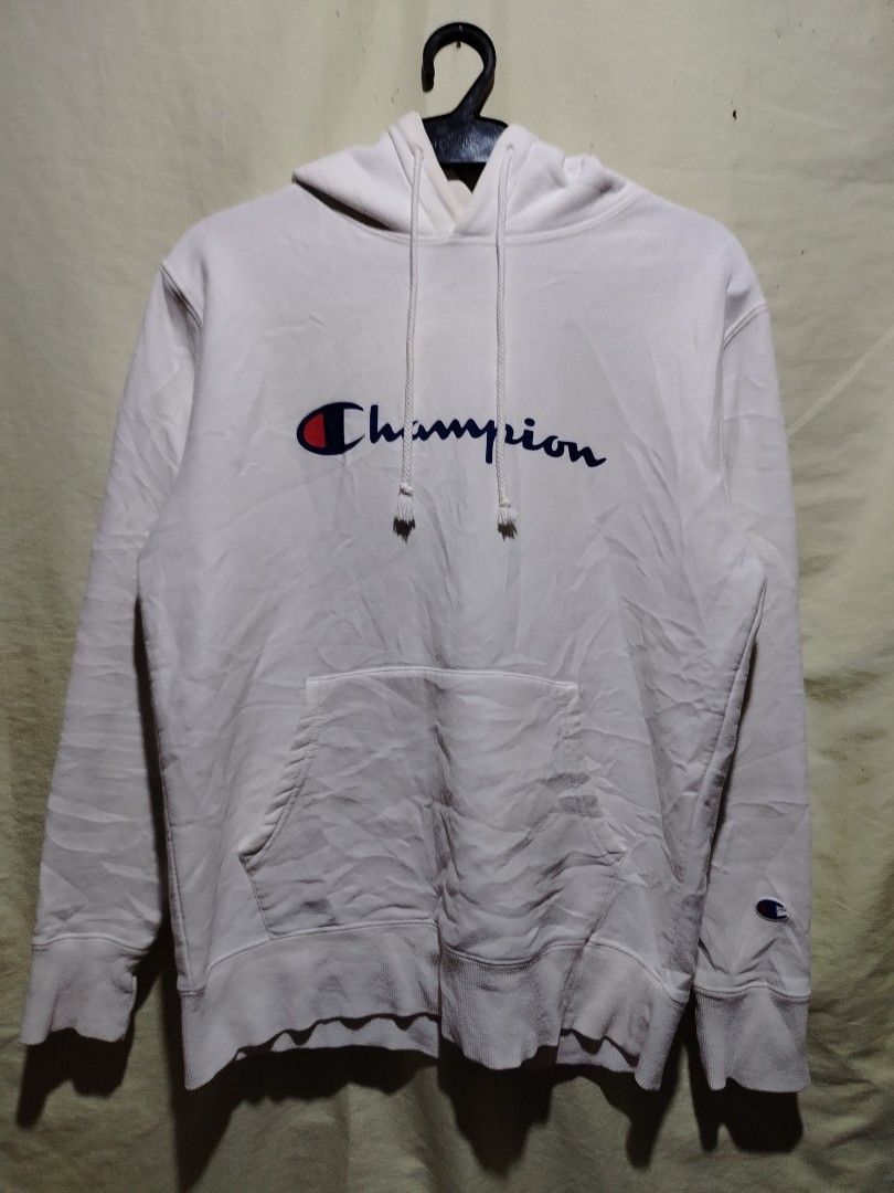 Champion White Hoodie Sweatshirt Medium (Category: Hoodies) located in Caloocan City. Submitted by vincefresn21903 (Listing ID 1468281752, Image 1). Description: - Brand: Champion - Style: Pullover hoodie with standard fit - Color: Classic White - Size: Medium - Design: Large script logo across the chest - Features: Kangaroo front pocket, drawstring hood, ribbed cuffs and hem - Detail: Small embroidered 'C' patch on the left wrist - Material: Com