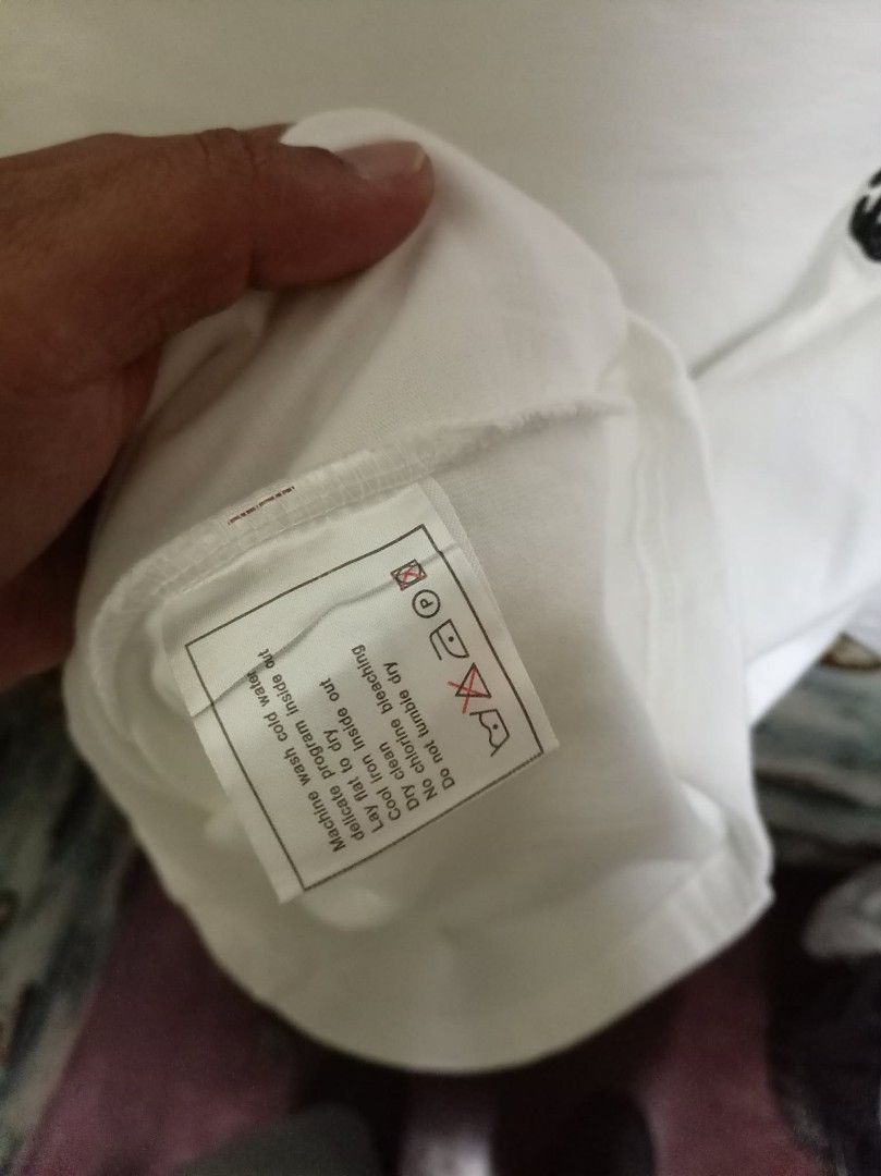 Chanel Uniform White T-Shirt Size 50 (Category: Shirts) located in Baguio. Submitted by jnjayceelbrn (Listing ID 1468172984, Image 3). Description: - Authentic white Chanel uniform crewneck t-shirt - Short sleeves with printed Chanel label on the right - Subtle embroidered CC logo on the chest - Tagged Size 50 at the collar - Clean white fabric, perfect as a simple everyday luxury piece - Includes interior care label with washing instructions.