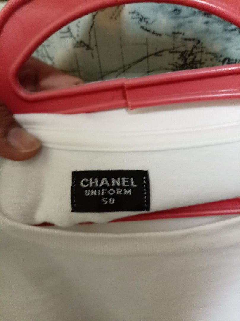 Chanel Uniform White T-Shirt Size 50 (Category: Shirts) located in Baguio. Submitted by jnjayceelbrn (Listing ID 1468172984, Image 2). Description: - Authentic white Chanel uniform crewneck t-shirt - Short sleeves with printed Chanel label on the right - Subtle embroidered CC logo on the chest - Tagged Size 50 at the collar - Clean white fabric, perfect as a simple everyday luxury piece - Includes interior care label with washing instructions.
