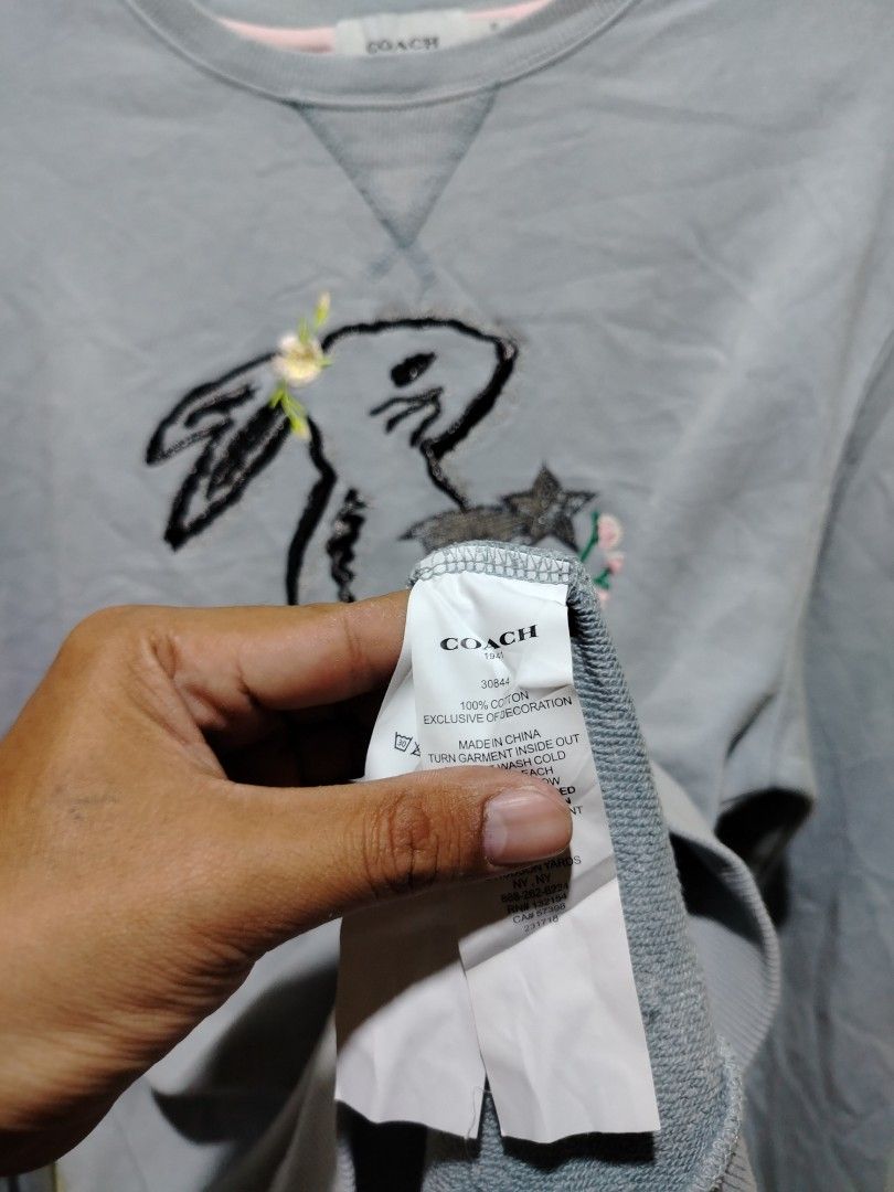 Coach 1941 Rabbit Embroidered Light Blue Sweatshirt Size 50 (Category: Coats, Jackets and Outerwear) located in Caloocan City. Submitted by vincefresn21903 (Listing ID 1468281859, Image 3). Description: - Brand: Coach 1941 - Color: Light Blue with rabbit embroidery and floral details - Size: 50 (tag attached) - Material: 100% cotton - Features: Ribbed crewneck, cuffs, and hem - Care: Wash inside out in cold water - Condition: Made in China, well-