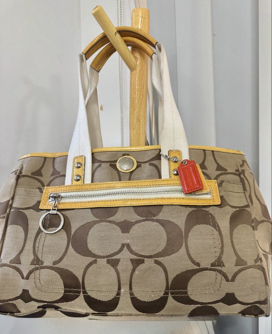Coach Daisy Signature Tote (Category: Tote Bags) located in Malolos. Submitted by urban_thrift_09 (Listing ID 1468141580, Image 1). Description: -Coach Daisy Signature Jacquard Tote Bag (Style F14878) featuring khaki and brown monogram jacquard canvas with yellow patent leather trim, double webbed straps, and a front zip pocket. -See photos for size & details.