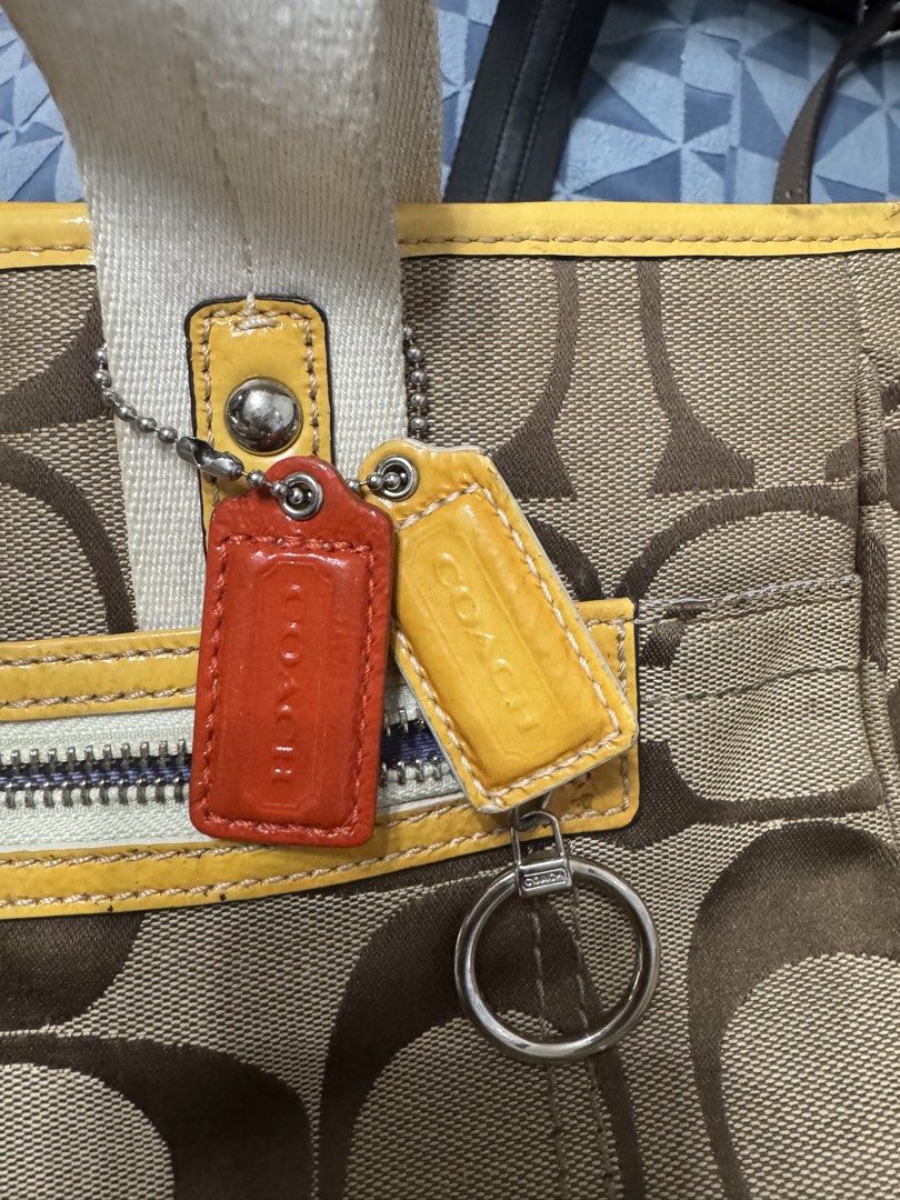Coach Daisy Signature Tote (Category: Tote Bags) located in Malolos. Submitted by urban_thrift_09 (Listing ID 1468141580, Image 2). Description: -Coach Daisy Signature Jacquard Tote Bag (Style F14878) featuring khaki and brown monogram jacquard canvas with yellow patent leather trim, double webbed straps, and a front zip pocket. -See photos for size & details.