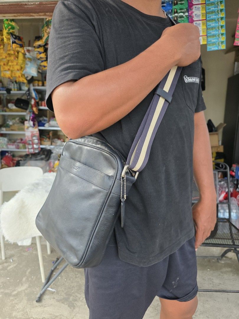 Coach Leather Crossbody Bag Black (Category: Cross-body Bags) located in Lemery. Submitted by venus23 (Listing ID 1468221748, Image 2). Description: - Brand: Coach - Material: Genuine black leather with pebbled texture - Color: Black with navy and tan webbed strap - Hardware: Silver-tone - Closure: Top zip closure - Compartments: Main compartment and front slip pocket - Strap: Thick, adjustable webbed strap - Dimensions: Roughly 25cm (W) x 26cm (