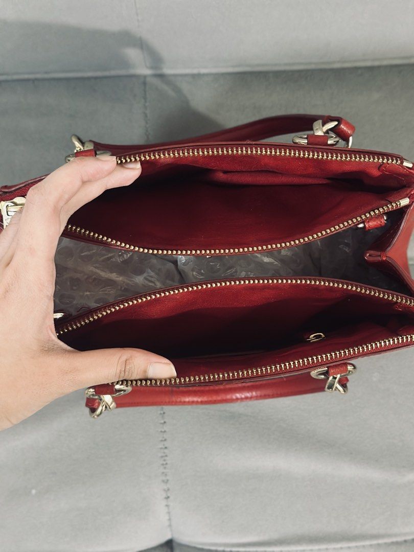 Coach Red Leather Satchel HandbIag (Category: Luxury Bags & Wallets) located in Tarlac. Submitted by via_banana (Listing ID 1468096506, Image 3). Description: - Brand: Coach - Material: Premium red pebbled leather - Hardware: Gold-tone throughout with hanging logo charm - Handles: Double rolled top handles - Closure: Secure zip-top closure - Interior: Fabric-lined with multiple compartments - Condition: Clean structure, well-maintained grain text