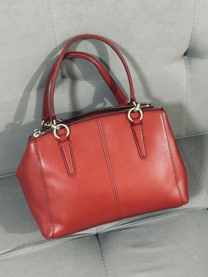 Coach Red Leather Satchel HandbIag (Category: Luxury Bags & Wallets) located in Tarlac. Submitted by via_banana (Listing ID 1468096506, Image 2). Description: - Brand: Coach - Material: Premium red pebbled leather - Hardware: Gold-tone throughout with hanging logo charm - Handles: Double rolled top handles - Closure: Secure zip-top closure - Interior: Fabric-lined with multiple compartments - Condition: Clean structure, well-maintained grain text