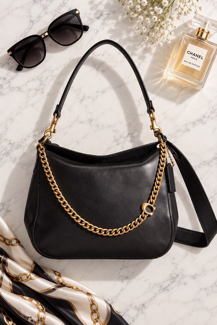Coach Signature Chain Hobo (Category: Cross-body Bags) located in Cebu City. Submitted by relovedfinds.ph (Listing ID 1468092323, Image 1). Description: The Coach Signature Chain Hobo is a timeless and elegant bag crafted from supple black leather with a structured base for a sophisticated silhouette. It features luxurious gold-tone hardware, a chunky decorative front chain, a detachable shoulder handle, and a detachable leather crossbody strap, 