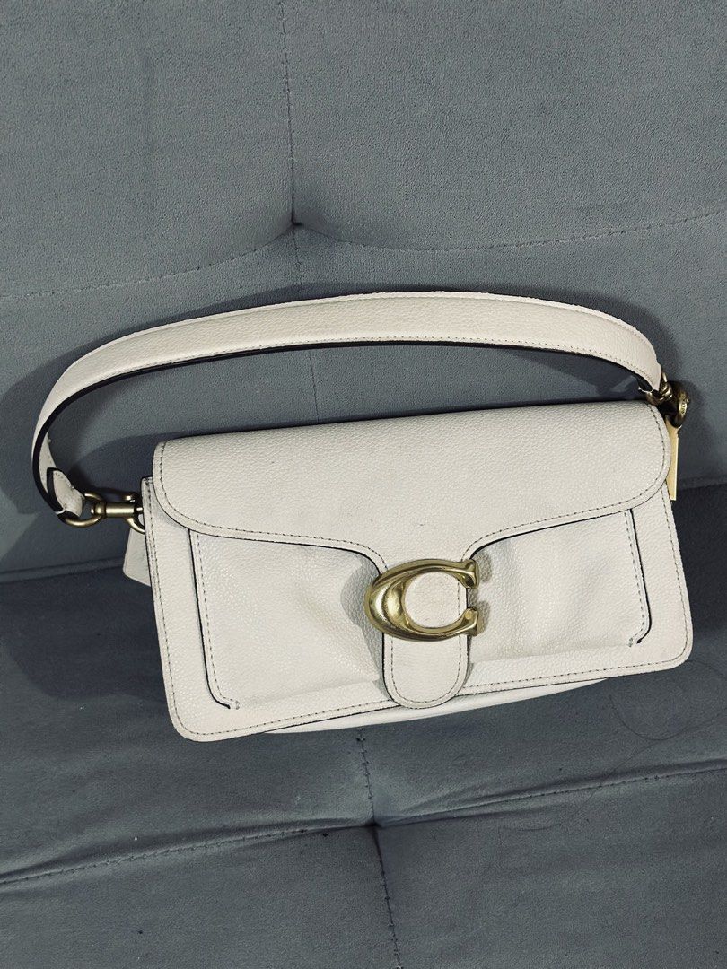 Coach Tabby Shoulder Bag White Leather (Category: Luxury Bags & Wallets) located in Tarlac. Submitted by via_banana (Listing ID 1468198586, Image 1). Description: - Brand: Coach - Material: White pebbled leather with tan suede lining - Hardware: Brass C hardware - Handle: Single detachable handle with Coach hangtag - Compartments: Center zip compartment, interior slip pocket, and back exterior slip pocket - Condition: Clean interior and exterior,