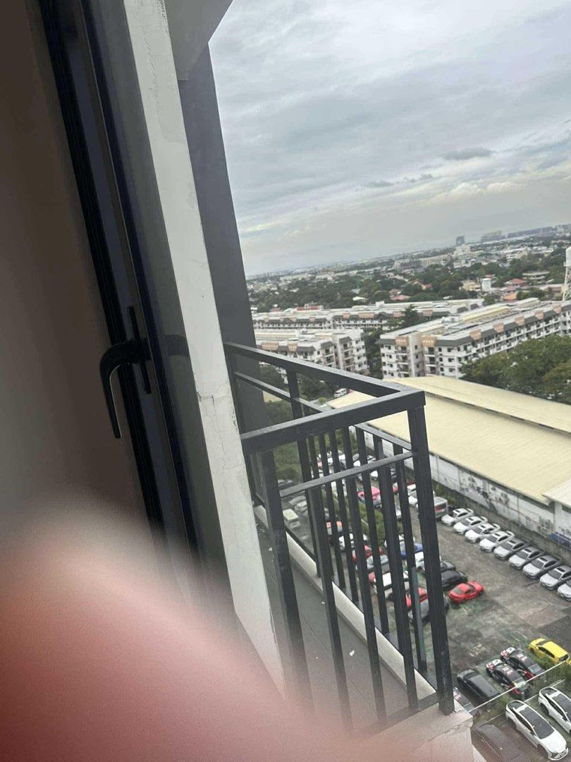 Condo Unit with City View and Pool Access (Category: Apartments & Condos) located in Manila. Submitted by ryanvflo36419 (Listing ID 1468070793, Image 2). Description: - Move-in ready condominium unit - Dark-framed windows with urban and parking area views - Access to shared outdoor swimming pool and palm tree surroundings inclusive of assoc.