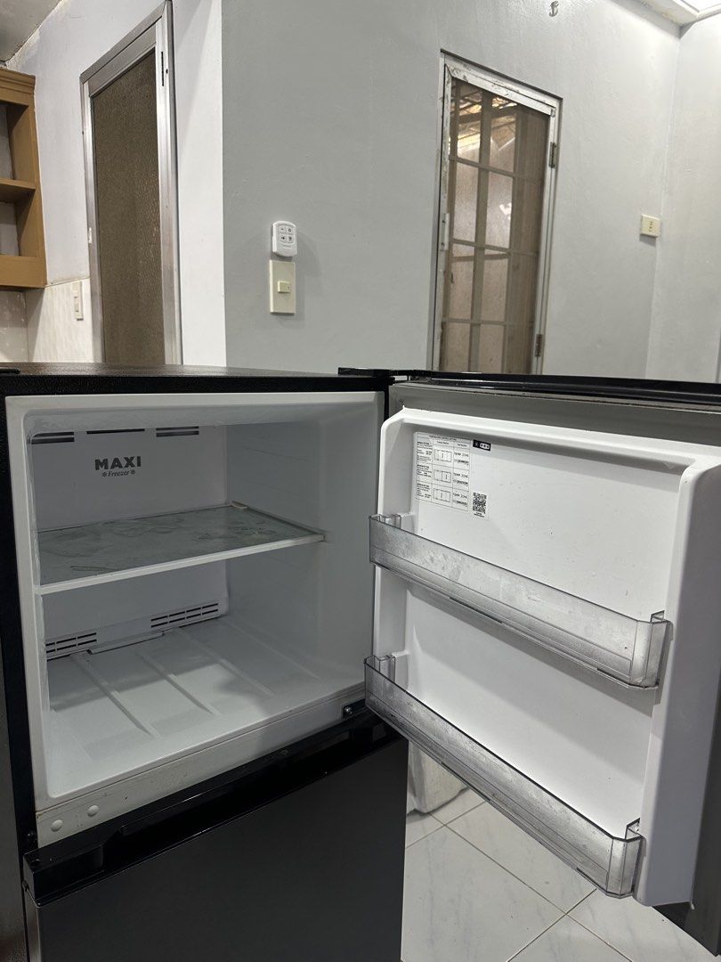 Condura CTF650i Inverter Refrigerator (Category: Refrigerators and Freezers) located in Cavite. Submitted by andreanico61694 (Listing ID 1468280578, Image 3). Description: - Brand/Model: Condura Inverter Refrigerator (CTF650i) - Type: Frost-free with energy label attached - Capacity: 179 liters total volume - Color: Sleek black finish - Features: Clean interior shelves, MAXI Fresh crisper drawer, and convenient door bins - Condition: Clean, well-