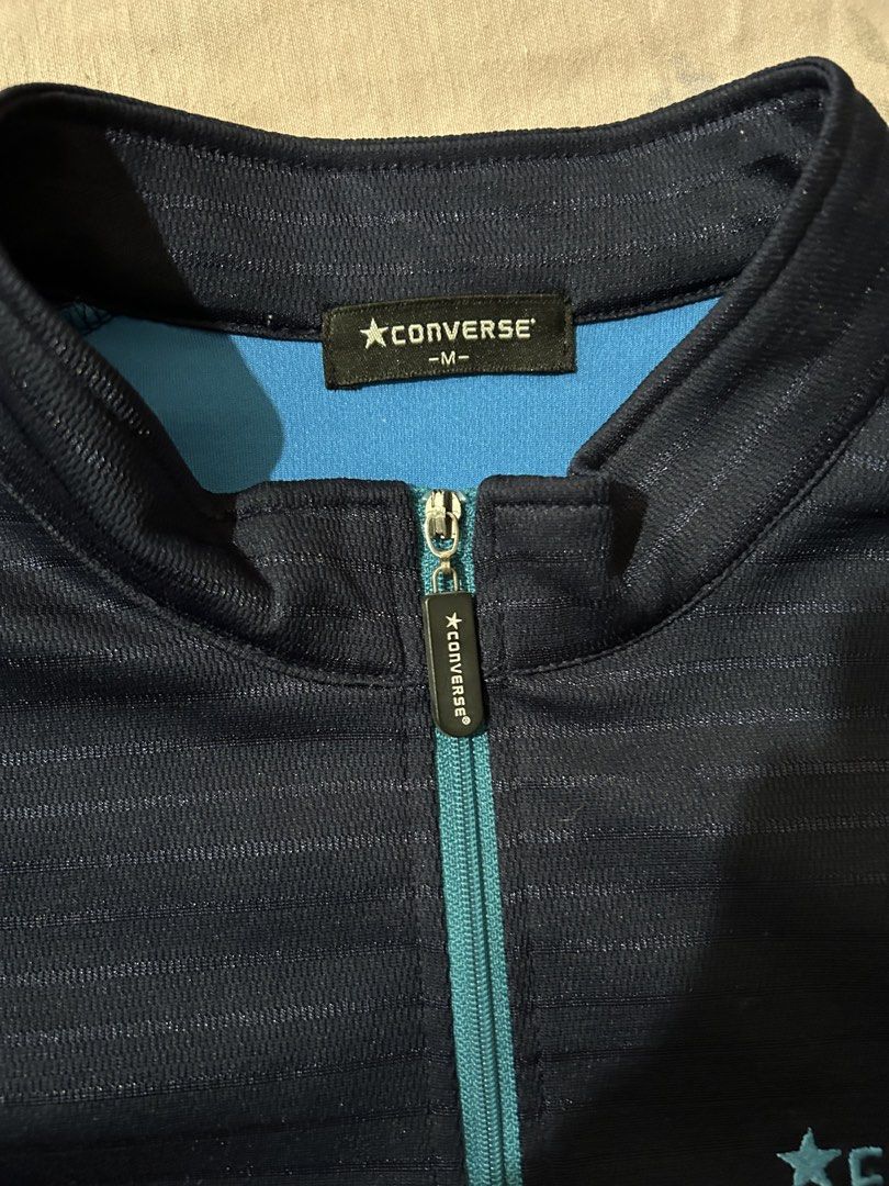 Converse Navy Blue Half Zip Polo Shirt Size M (Category: Tshirts & Polo Shirts ) located in Cebu City. Submitted by purephoenix-2e10a3 (Listing ID 1468092208, Image 2). Description: - Brand: Converse - Color: Navy blue with light blue shoulder stripes and matching zipper - Size: M - Details: Embroidered Converse logo on left chest, subtle horizontal line texture throughout fabric - Style: Great for athletic or casual wear.