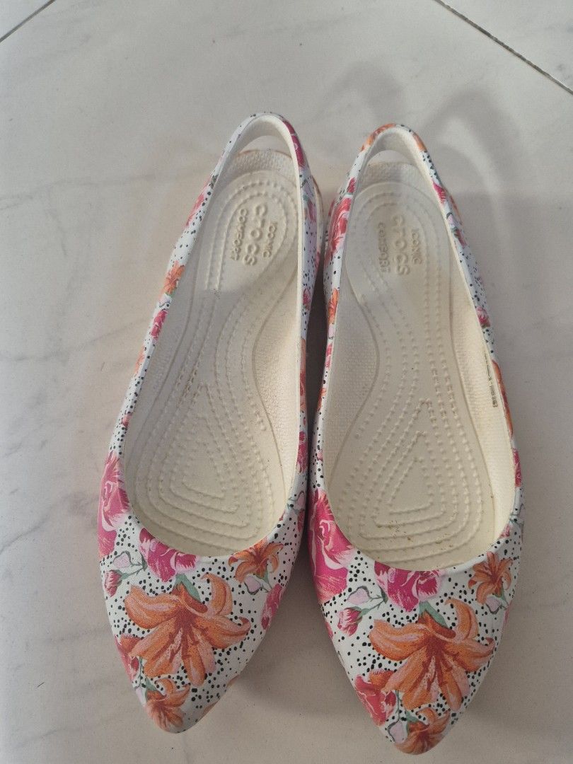 Crocs Floral Pointed Toe Flats W5 (Category: Flats & Sandals) located in San Jose. Submitted by nova2023 (Listing ID 1468074957, Image 1). Description: - Brand: Crocs - Style: Slip-on flats with a sleek pointed toe - Design: Vibrant orange lily and pink rose print on a polka dot background - Comfort: Iconic Crocs comfort footbed for all-day cushioning - Size: Women's US 5 - Condition: Good, with minor wear on the soles from previous use.