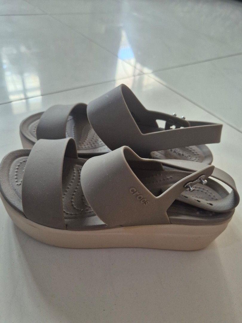 Crocs LiteRide Strappy Wedge Sandals (Category: Sandals) located in San Jose. Submitted by nova2023 (Listing ID 1468074772, Image 2). Description: - Color: Taupe - Size: W5 (stamped on outsole) - Comfort: Ultra-soft LiteRide foam footbed - Design: Two wide upper straps and adjustable ankle strap with convenient snap buttons - Sole: Lightweight wedge with excellent grip underneath - Condition: Worn a few times with minimal wear on the treads.
