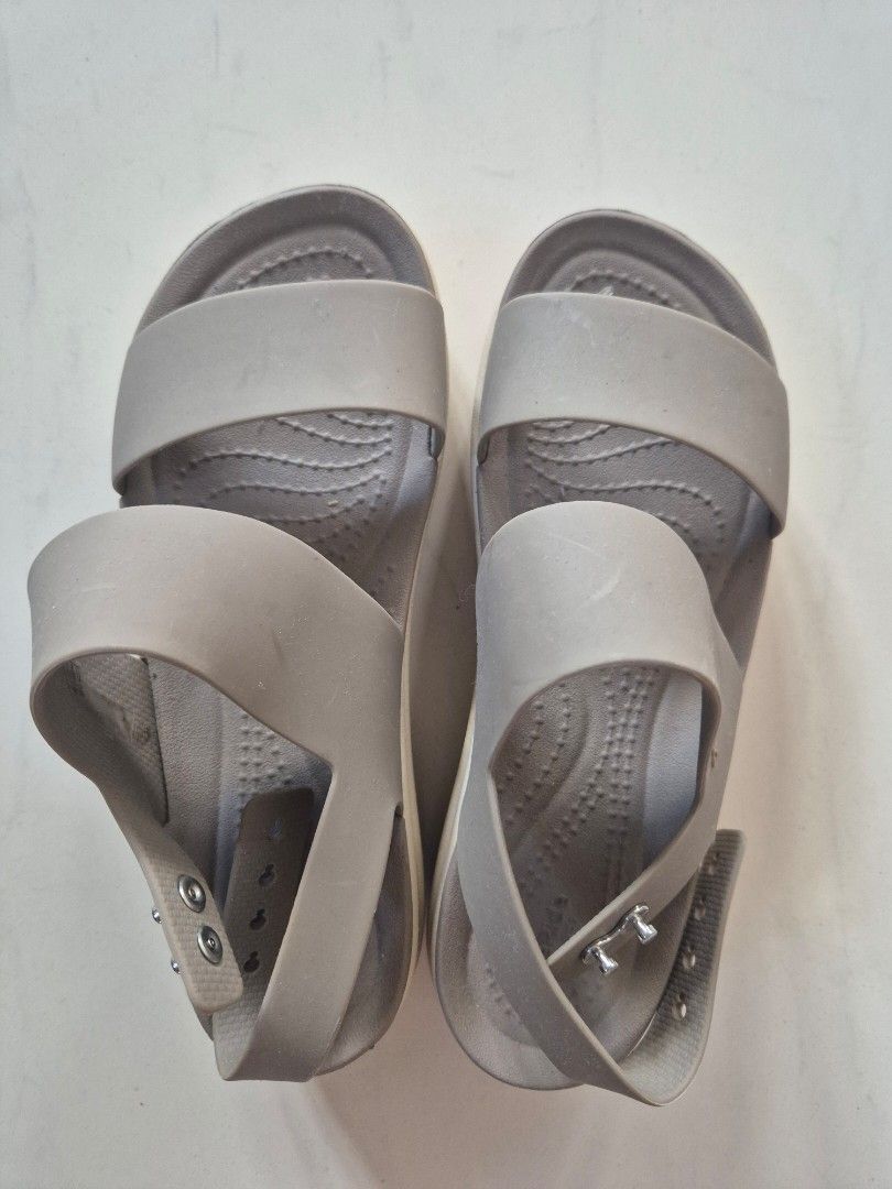 Crocs LiteRide Strappy Wedge Sandals (Category: Sandals) located in San Jose. Submitted by nova2023 (Listing ID 1468074772, Image 3). Description: - Color: Taupe - Size: W5 (stamped on outsole) - Comfort: Ultra-soft LiteRide foam footbed - Design: Two wide upper straps and adjustable ankle strap with convenient snap buttons - Sole: Lightweight wedge with excellent grip underneath - Condition: Worn a few times with minimal wear on the treads.