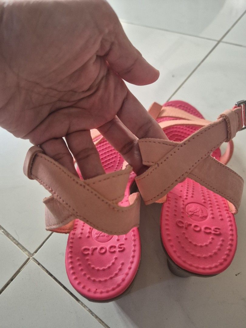 Crocs Wedge Sandals Pink Orange Size W6 (Category: Sandals) located in San Jose. Submitted by nova2023 (Listing ID 1468074861, Image 3). Description: - Brand: Crocs - Style: Wedge sandals with double front straps and adjustable ankle buckle - Color: Bright pink and peach - Size: Women's W6 - Sole: Wedge heel with textured rubber for grip - Condition: Clean footbed, solid thick treads, and minor sticker residue at the heel bottom.