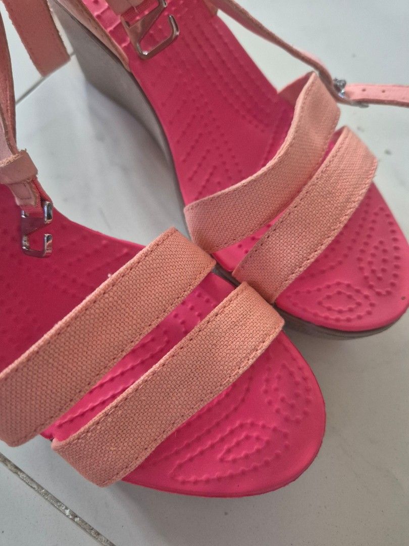 Crocs Wedge Sandals Pink Orange Size W6 (Category: Sandals) located in San Jose. Submitted by nova2023 (Listing ID 1468074861, Image 2). Description: - Brand: Crocs - Style: Wedge sandals with double front straps and adjustable ankle buckle - Color: Bright pink and peach - Size: Women's W6 - Sole: Wedge heel with textured rubber for grip - Condition: Clean footbed, solid thick treads, and minor sticker residue at the heel bottom.