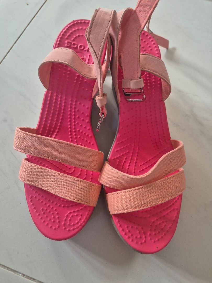 Crocs Wedge Sandals Pink Orange Size W6 (Category: Sandals) located in San Jose. Submitted by nova2023 (Listing ID 1468074861, Image 1). Description: - Brand: Crocs - Style: Wedge sandals with double front straps and adjustable ankle buckle - Color: Bright pink and peach - Size: Women's W6 - Sole: Wedge heel with textured rubber for grip - Condition: Clean footbed, solid thick treads, and minor sticker residue at the heel bottom.