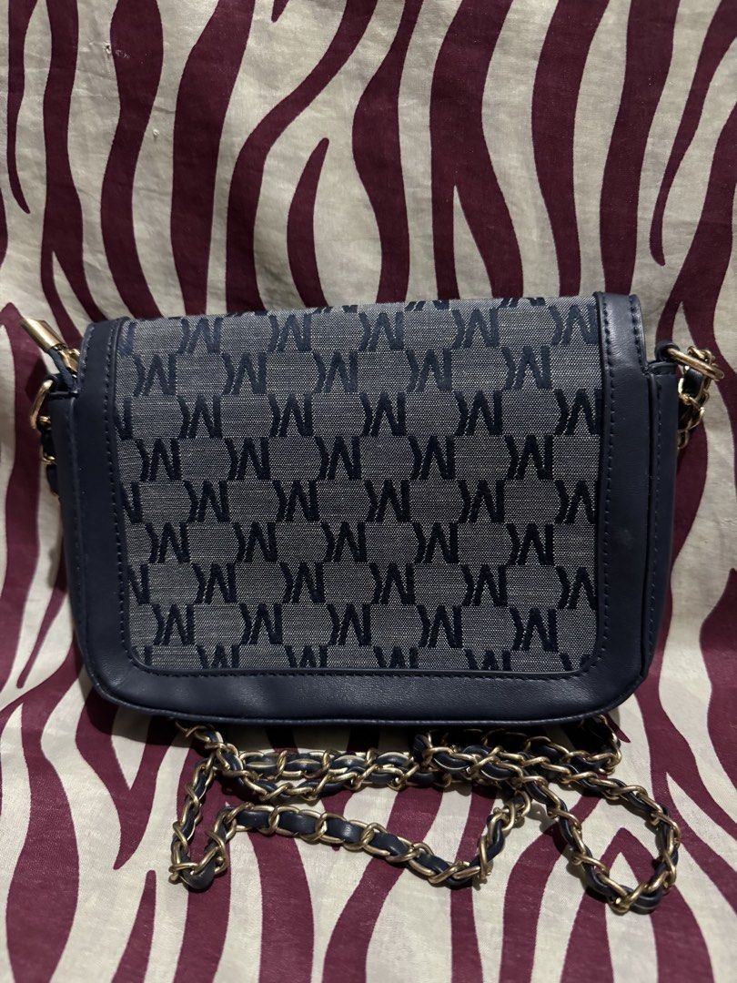 Cross-body bags (Category: Cross-body Bags) located in Taguig. Submitted by justlikenewthriftshop.ph (Listing ID 1468135464, Image 2). Description: Navy blue cross-body bag with monogram print, gold hardware, and a chain strap. Features a zippered main compartment and inside pockets. Stylish and convenient for everyday use. 💵: GCash/BPI 🚚: J&T/LBC 🏍️: Grab/Lalamove 📍Taguig City .