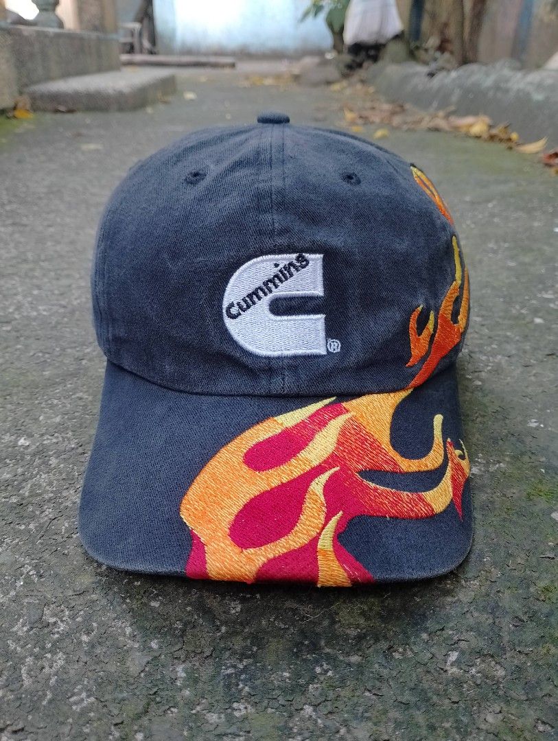 Cummins Rocky Mountain Flame Embroidered Baseball Cap (Category: Caps & Hats) located in Bago City. Submitted by the_outcast6101 (Listing ID 1468279063, Image 2). Description: - Color: Dark grey with washed denim style - Embroidery: White Cummins logo on front and colorful flames along sides and brim - Details: 'BEST...EVERY TIME, EVERY DAY' text above the back strap - Branding: Cummins and Rocky Mountain logo on the back strap - Closure: Adjusta