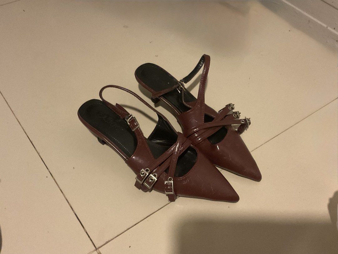 Dark brown pointed toe kitten heels with buckle straps (Category: Heels) located in Cebu City. Submitted by sof09 (Listing ID 1468103310, Image 1). Description: - Color: Dark brown - Style: Pointed toe kitten heels with slingback strap - Details: Multiple decorative front buckles, dark insoles - Heel: Low height for all-day comfort - Condition: Smooth finish with visible wear and light scuffs on the toes.