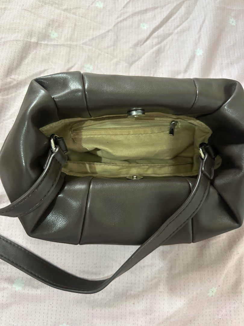 Dark Brown PU Leather Shoulder Bag (Category: Shoulder Bags) located in Lipa City. Submitted by chiechums (Listing ID 1468105477, Image 2). Description: - Color & Material: Dark brown smooth faux leather - Design: Structured pleated style with paneling details and silver-tone hardware - Closure: Secure magnetic snap top closure - Interior: Clean beige fabric lining with one handy zippered pocket - Condition: Clean inside and out, ready to use.