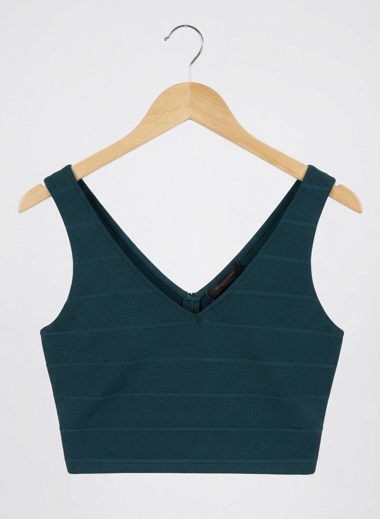 Dark Green V-Neck Zip Crop Top (Category: Shirts) located in Cavite. Submitted by grandearth.39df3f (Listing ID 1468119119, Image 1). Description: - Color: Dark teal - Material: Thick, ribbed bandage fabric with horizontal knit pattern - Design: Deep V-neckline on front and back - Closure: Heavy-duty silver metal zipper down the back - Fit: Fitted silhouette that hugs the body tightly - Condition: Brand new with tag attached.