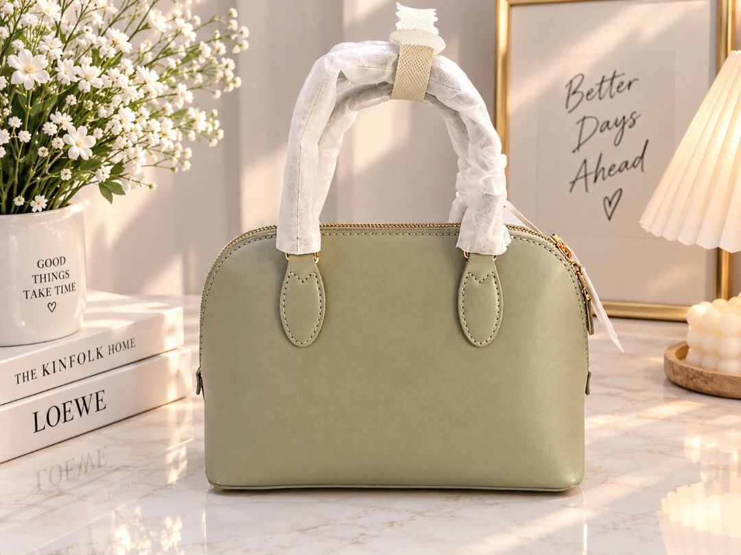 David Jones Paris Green Dome Handbag (Category: Luxury Bags & Wallets) located in Quezon City. Submitted by iza_collection07 (Listing ID 1468206636, Image 2). Description: - Brand: David Jones Paris - Style: Sage green dome handbag - Hardware: Gold-tone with matching zipper pulls - Accent: Padlock charm - Material: Structured faux leather with top zip closure - Condition: Brand new, never used, handles still wrapped in original protective paper.