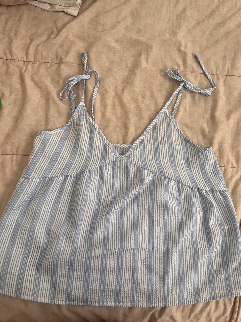 Dazy Blue and White Striped Camisole Size L (Category: Sleeveless) located in Marikina City. Submitted by yeun0923 (Listing ID 1468099430, Image 1). Description: - GCASH MOP - Buyer handles SF - JRS or Lalamove - Style: V-neckline with adjustable tie-up shoulder straps - Material: Lightweight crinkled fabric - Condition: Clean and ready to wear.