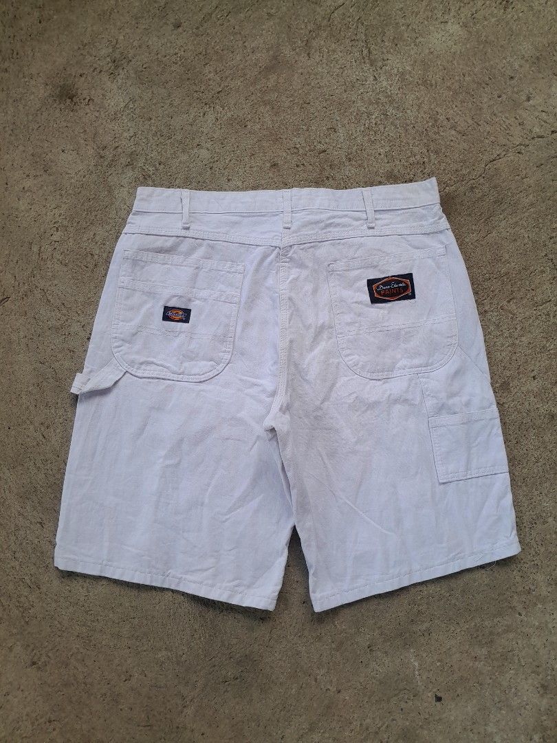 Dickies Dunn-Edwards Paints White Carpenter Shorts (Category: Shorts) located in Bayabas. Submitted by justhriftwithme (Listing ID 1468068531, Image 3). Description: - Brand: Dickies x Dunn-Edwards Paints - Style: White carpenter shorts with vintage look - Features: Rare back pocket collaboration patch, classic hammer loop, and utility pockets - Hardware: Button closure with embossed logo branding - Material: Durable cotton canvas - Fit: Great st