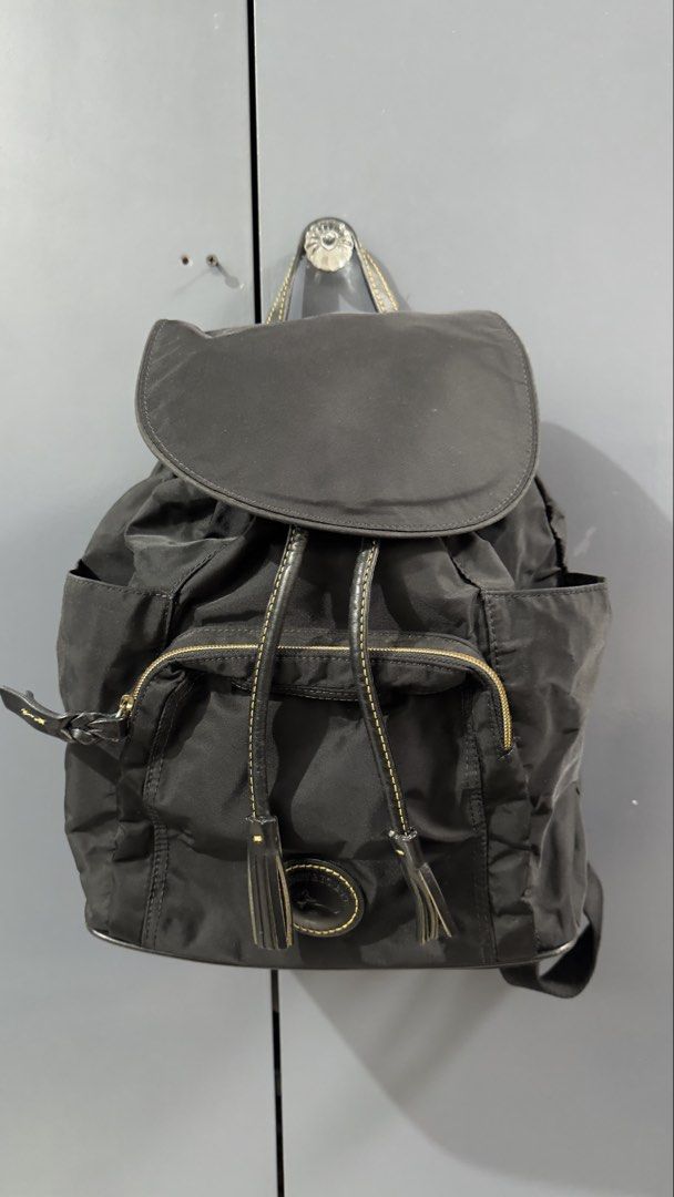 Dooney & Bourke Black Nylon Backpack (Category: Backpacks) located in Quezon City. Submitted by dendionlineshop (Listing ID 1468146862, Image 1). Description: - Brand: Dooney & Bourke - Material: Durable black nylon with contrast yellow stitching - Closure: Front flap with magnetic snap and drawstring pull - Pockets: Front zipper pocket, side slip pockets, and interior zippered pocket - Straps: Top carry handle and adjustable shoulder straps - Ha