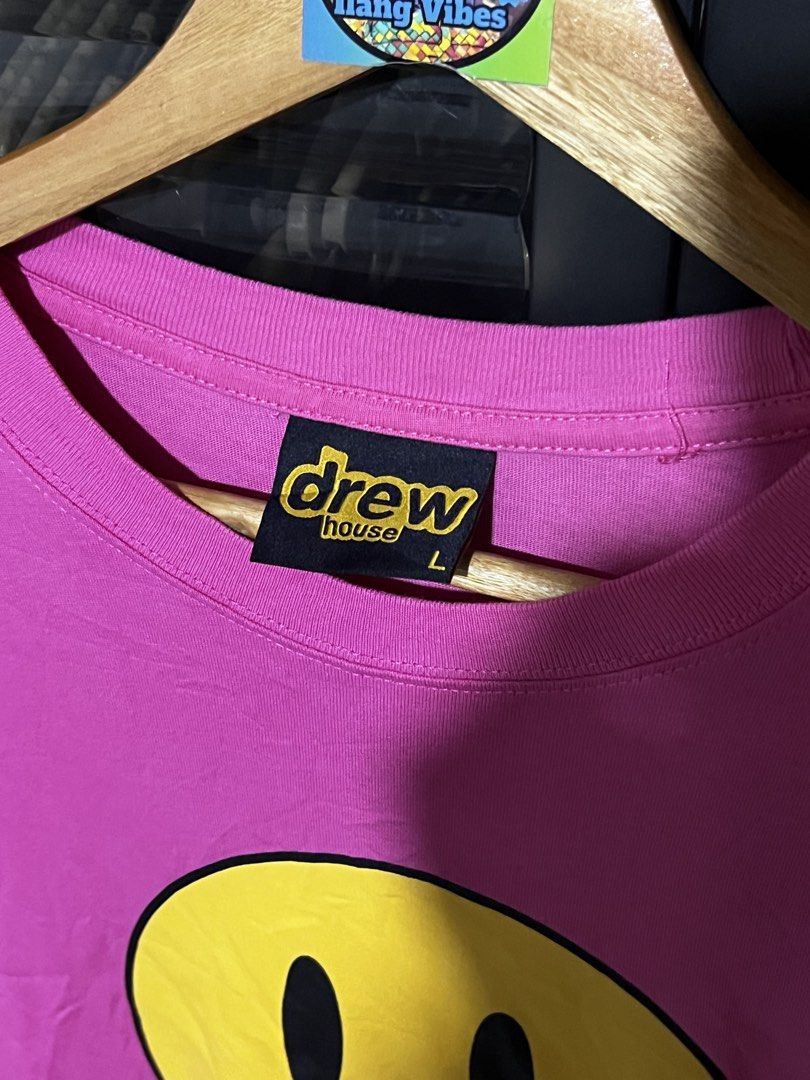 Drew House Pink Mascot SS Tee Size L (Category: Tshirts & Polo Shirts ) located in Davao. Submitted by thriftitemsss (Listing ID 1468196392, Image 2). Description: - Brand: Drew House - Item: Short sleeve tee - Color: Bright pink with iconic yellow smiley face graphic and black 'drew' lettering - Size: Large (verified by black collar tag) - Material: 100% cotton (interior care tag included) - Details: Ribbed crew neck collar, made in Vietnam, RN 
