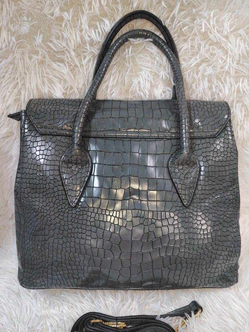 Eastside Grey Crocodile Texture Handbag with Strap (Category: Cross-body Bags) located in Quezon City. Submitted by zhelcloset01 (Listing ID 1468236479, Image 2). Description: - Color: Grey with stylish crocodile texture pattern throughout - Design: Structured shape with elegant gold-tone hardware and flap closure with metallic accent - Versatility: Includes dual top handles and a detachable strap for shoulder or hand carry - Interior: Dark brown
