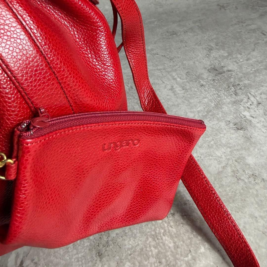 Emanuel Ungaro Red Leather Bucket Bag with Pouch (Category: Luxury Bags & Wallets) located in Manila. Submitted by ryoughhthrift (Listing ID 1468094732, Image 3). Description: - Brand: Emanuel Ungaro - Material: Premium textured leather in a bright red shade - Closure: Secure drawstring top - Strap: Adjustable shoulder strap for a custom fit - Bonus: Includes a matching detachable zippered pouch connected by a chic gold chain - Base: Flat oval ba