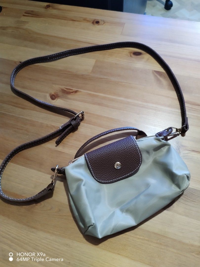 Everyday bag (Category: Purses & Pouches) located in Muntinlupa City. Submitted by arciagamaryann68 (Listing ID 1468104855, Image 2). Description: - Style: Everyday casual crossbody / shoulder bag - Color: Beige body with brown textured flap and strap details - Material: Durable nylon with leatherette accents - Closure: Zipper main compartment with snap-button flap - Strap: Adjustable and removable long strap - Condition: Excellent, well-maintain