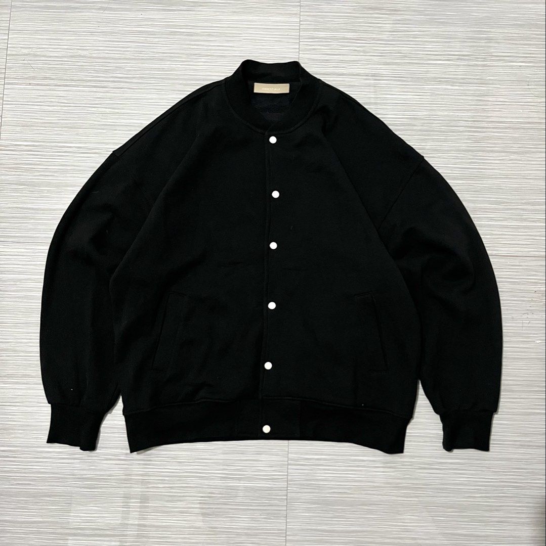 Fear of God Essentials Varsity Jacket / Snap Jacket in black (Category: Coats, Jackets and Outerwear) located in Santa Cruz. Submitted by youngearth.c72f95 (Listing ID 1468059974, Image 2). Description: EXCELLENT CONDITION ISSUE-MISSING 2 BUTTON SEE THE PIC DIMES-26x28 L ON TAG.