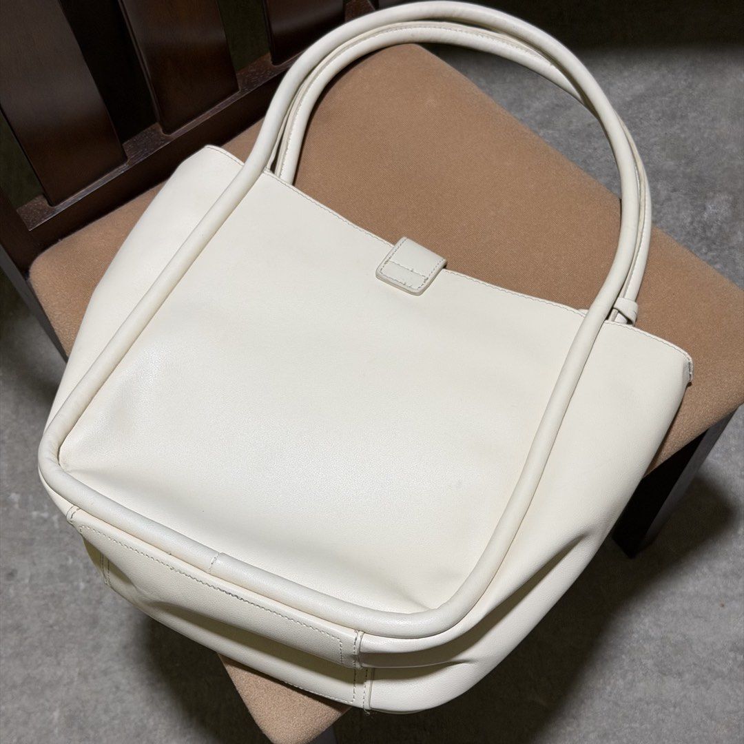 Figlia Jester Handbag Cream Color (Category: Shoulder Bags) located in Caloocan City. Submitted by catwonrideul (Listing ID 1468141321, Image 3). Description: - Brand/Model: Figlia Jester Handbag - Color: Cream - Original Price: ₱1,499 - Design: Structured with dual shoulder straps, gold-tone hardware, and front logo charm - Closure: Zip-top for security - Interior: Smooth lining with multi-compartments and side pockets - With FLAW - nagkapunit s