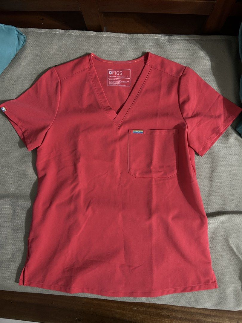 FIGS Technical Collection Scrub Top Coral Size S (Category: Others Tops) located in Pasig City. Submitted by piayayaya511 (Listing ID 1468237121, Image 1). Description: - Brand: FIGS (Technical Collection) - Color: Bright Coral Pink - Size: Small (printed collar tag) - Style: V-neck, short sleeves, one chest pocket - Details: Rainbow accent tags on pocket and sleeve, vertical back dart seams for a tailored fit - Condition: Excellent, clean fabric