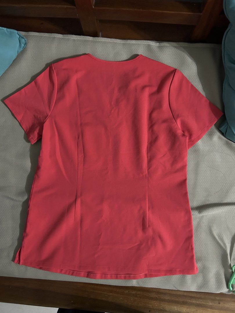 FIGS Technical Collection Scrub Top Coral Size S (Category: Others Tops) located in Pasig City. Submitted by piayayaya511 (Listing ID 1468237121, Image 2). Description: - Brand: FIGS (Technical Collection) - Color: Bright Coral Pink - Size: Small (printed collar tag) - Style: V-neck, short sleeves, one chest pocket - Details: Rainbow accent tags on pocket and sleeve, vertical back dart seams for a tailored fit - Condition: Excellent, clean fabric