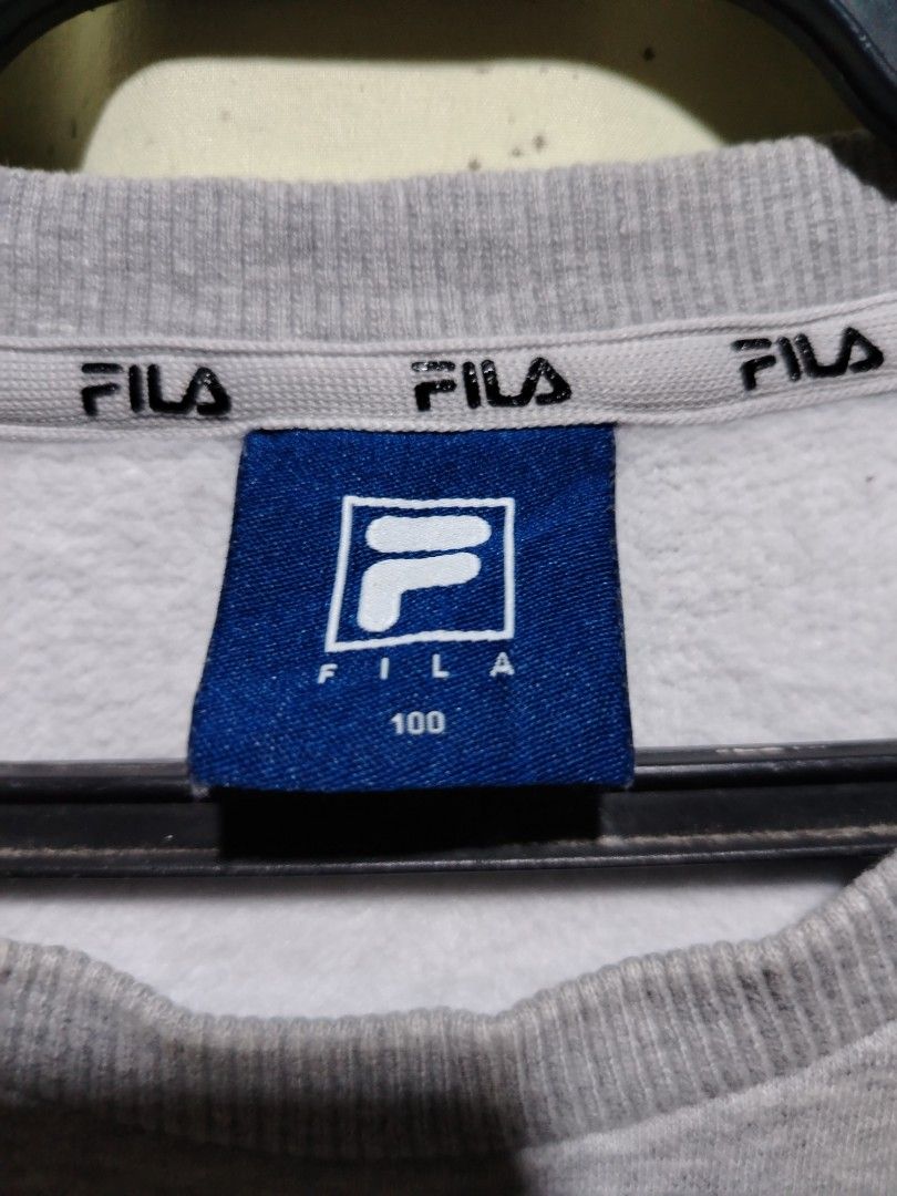 Fila Grey Sweatshirt Size 100 (Category: Coats, Jackets and Outerwear) located in Caloocan City. Submitted by vincefresn21903 (Listing ID 1468281766, Image 2). Description: - Authentic Fila grey sweatshirt - Bold embroidered logo across the chest - Signature Fila branding on the left sleeve cuff - Comfortable ribbed collar, cuffs, and hem - Size tag: 100 - Features stylish repeating Fila text on the inside neck tape.