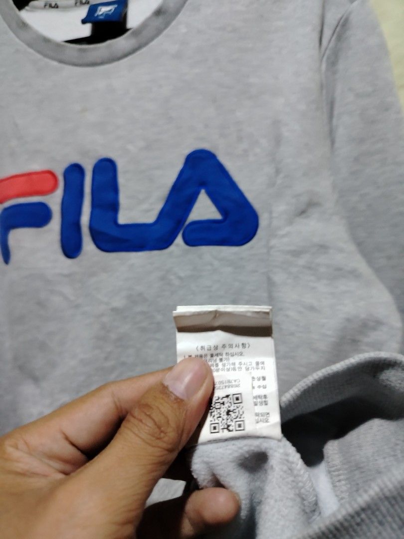 Fila Grey Sweatshirt Size 100 (Category: Coats, Jackets and Outerwear) located in Caloocan City. Submitted by vincefresn21903 (Listing ID 1468281766, Image 3). Description: - Authentic Fila grey sweatshirt - Bold embroidered logo across the chest - Signature Fila branding on the left sleeve cuff - Comfortable ribbed collar, cuffs, and hem - Size tag: 100 - Features stylish repeating Fila text on the inside neck tape.