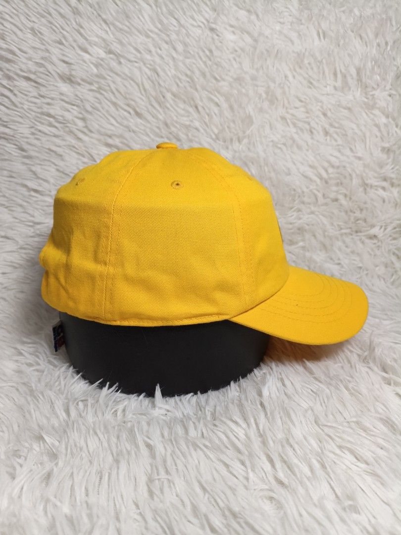 Fila Yellow Baseball Cap Embroidered Logo Adjustable Strap (Category: Caps & Hats) located in Imus. Submitted by grindhouse.thriftshop (Listing ID 1468125499, Image 2). Description: - Color: Bright yellow - Design: Embroidered oval Fila patch on front, small logo on back, and white Fila flag label near the strap - Fit: Adjustable strap with a metal clasp for a customized fit - Brim: Curved brim with detailed stitching - Condition: Clean fabric, r