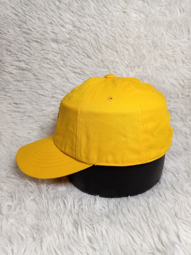 Fila Yellow Baseball Cap Embroidered Logo Adjustable Strap (Category: Caps & Hats) located in Imus. Submitted by grindhouse.thriftshop (Listing ID 1468125499, Image 3). Description: - Color: Bright yellow - Design: Embroidered oval Fila patch on front, small logo on back, and white Fila flag label near the strap - Fit: Adjustable strap with a metal clasp for a customized fit - Brim: Curved brim with detailed stitching - Condition: Clean fabric, r
