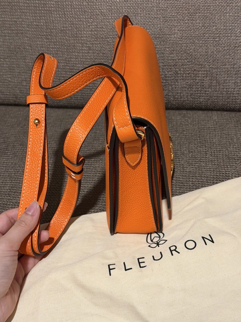 Fleuron Orange Leather Shoulder Bag (Category: Luxury Bags & Wallets) located in General Santos City (Dadiangas). Submitted by mereyelle (Listing ID 1468172980, Image 3). Description: - Brand/Model: Fleuron leather handbag - Color: Bright orange - Hardware: Gold-tone flower clasp closure - Design: Structured body with multiple interior compartments - Strap: Adjustable matching orange leather strap included - Inclusions: Original white cotton dust