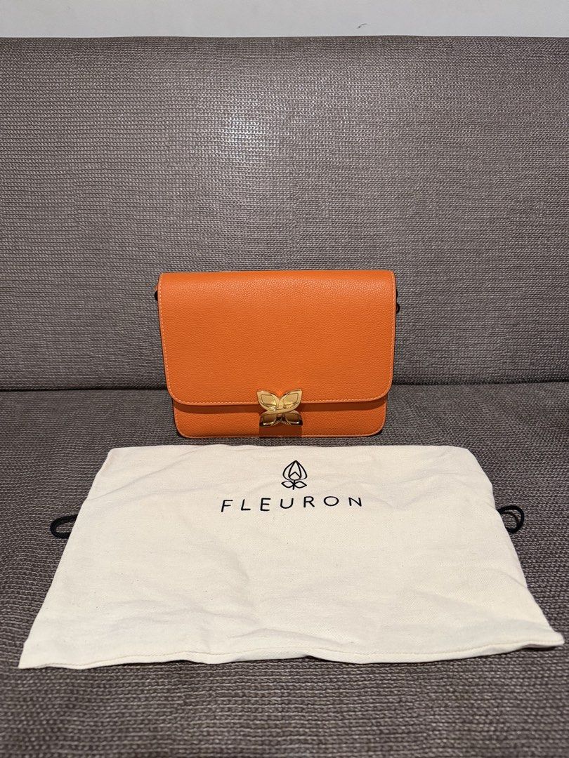 Fleuron Orange Leather Shoulder Bag (Category: Luxury Bags & Wallets) located in General Santos City (Dadiangas). Submitted by mereyelle (Listing ID 1468172980, Image 1). Description: - Brand/Model: Fleuron leather handbag - Color: Bright orange - Hardware: Gold-tone flower clasp closure - Design: Structured body with multiple interior compartments - Strap: Adjustable matching orange leather strap included - Inclusions: Original white cotton dust